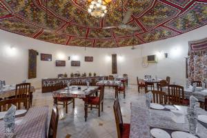 a dining room with tables and chairs and a ceiling at Kutch Safari Resort in Kunria +25 photos