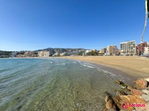 - une vue sur une plage avec des bâtiments en arrière-plan dans l'établissement El Bungalow, à Oropesa del Mar