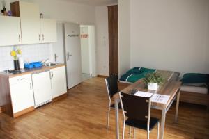 a kitchen and a dining room with a table and chairs at Koxsi's Motorhome in Spielberg