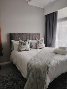 a bedroom with a large bed with white sheets and pillows at Menlyn Maine Trilogy Apartment 519 in Pretoria +13 photos