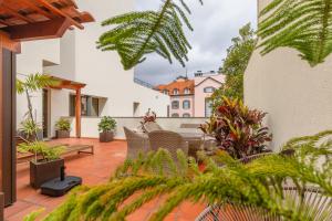 eine Außenterrasse mit Stühlen und Pflanzen in der Unterkunft The Suite QM in Funchal