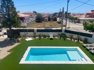 a backyard with a swimming pool and green grass at Villa Paymu in Miami Platja