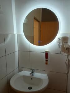 ein Badezimmer mit Waschbecken und Spiegel in der Unterkunft Niehler Hotel in Köln + 32 Fotos