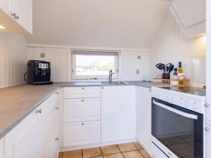 a white kitchen with a sink and a window at Cozy Beach House in Vejers - By Traum Ferienwohnungen in Vejers Strand