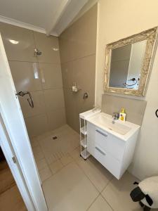 a bathroom with a shower and a sink and a mirror at Railway Cottage at Rawdons Country Estate in Nottingham Road