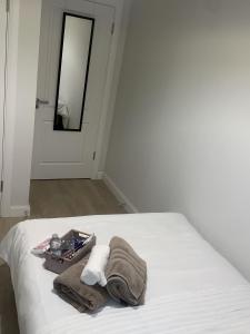 a white bed with a suitcase and towels on it at The Sheltuh in Dublin