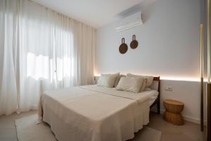Un dormitorio con una cama con sábanas blancas y una ventana. en Cortina Luxe Lodge, en Voluntari