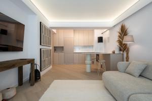 Una sala de estar con un sofá y una cocina. en Cortina Luxe Lodge, en Voluntari