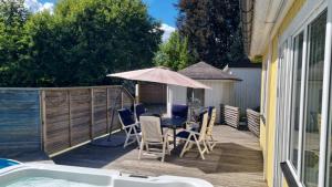 a deck with a table and chairs and an umbrella at Gula huset in Perstorp