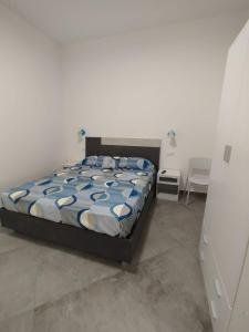 a bedroom with a bed with a blue and white comforter at Camere d'a mare in Capo dʼOrlando