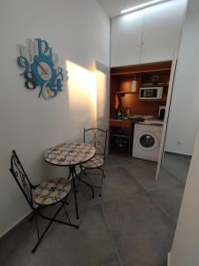 a kitchen with a table and two chairs and a table and a microwave at Camere d'a mare in Capo dʼOrlando