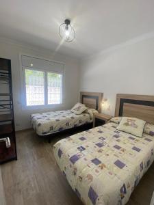 a bedroom with two beds and a window at Villa Paymu in Miami Platja +4 photos