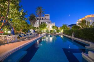 a swimming pool at night with chairs and a building at Hotel Villa Paradiso in Ischia Town