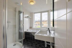 a bathroom with two sinks and a shower and a toilet at Family home in Haarlem with garden, near beach & Amsterdam in Haarlem