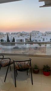 a balcony with a chair and a view of a city at Stylish Sahloul 4 Apartment with Balcony in Sousse