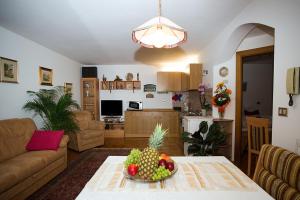 un soggiorno con tavolo e cesto di frutta; di Cesa Sule de Sot a Ortisei