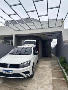 a white car parked in front of a garage at Friends of Nature House in Cotia +3 photos