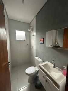 a bathroom with a white toilet and a sink at Friends of Nature House in Cotia