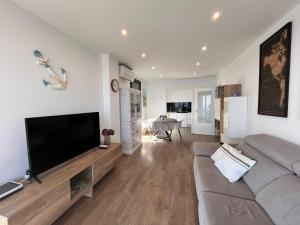 a living room with a couch and a flat screen tv at Apartment SEA VIEW in Llança