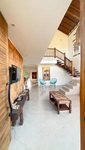a living room with a tv and a wooden wall at Casa Odara Trancoso in Trancoso