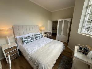 a bedroom with a bed and a table and a window at Railway Cottage at Rawdons Country Estate in Nottingham Road