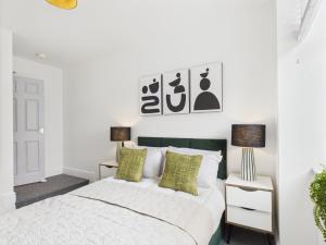 een witte slaapkamer met een bed en 2 lampen bij Spacious Apartment with Private Garden in Norwich