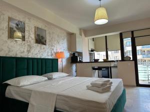 a bedroom with a large bed with towels on it at Studio near Copou Hospitals IRO Parhon in Iaşi