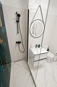 a bathroom with a shower and a sink and a mirror at Central Aparthotel in Galaţi +14 photos