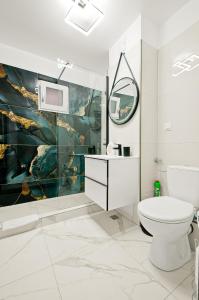 a bathroom with a toilet and a painting on the wall at Central Aparthotel in Galaţi