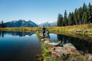 a man and a boy standing next to a river at Old Town City Center Apartment Post in Zell am See +6 photos