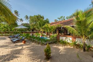 un complejo con sillas y mesas en la playa en Palm Villa A private beach sanctuary, en Mararikulam