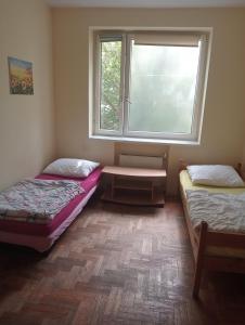 deux lits dans une chambre avec une fenêtre dans l'établissement Macedonia Home, à Varsovie