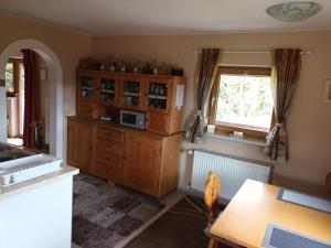 a kitchen with a wooden cabinet and a microwave at Ferienwohnung in Sauerlach