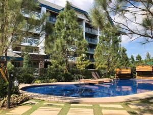a swimming pool in front of a building at Pine Suites Staycation at Tagaytay in Tagaytay