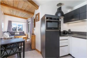 モルジヌにあるAvoriaz 1800 - Tilia appartement de charmeの黒い冷蔵庫とテーブルのあるキッチン