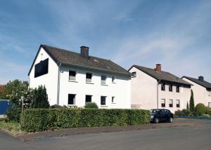a black car parked in front of a white house at Ferienwohnung Marita in Rietberg