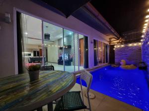 a dining room with a table and a swimming pool at ChinJu PoolVilla in Jomtien Beach