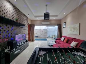 a living room with a red couch and a pool table at ChinJu PoolVilla in Jomtien Beach