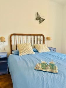 a bed with a tray with two tea cups on it at Casa Claudio Palomar in Palomar de Arroyos +12 photos