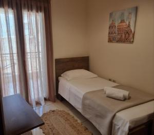 a small bedroom with two beds and a table at Master Residence Lavrion in Lávrion +7 photos