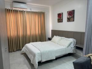 a bedroom with a bed and a window with curtains at Apartamento em Foz do Iguaçu, Ravello Residencial in Foz do Iguaçu