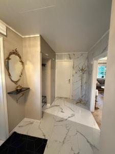 un soggiorno con pavimento in marmo e specchio di Villa Hana a Sandnes