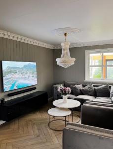 un soggiorno con divano e TV a schermo piatto di Villa Hana a Sandnes