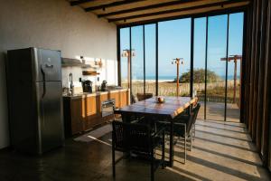 a kitchen with a wooden table and a refrigerator at Vila Cangalha in Camocim