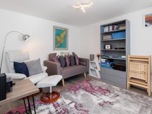 a living room with a couch and a book shelf at Weavers Cottage in Back