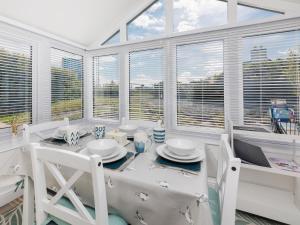 a dining room with a table and chairs and windows at Weavers Cottage in Back