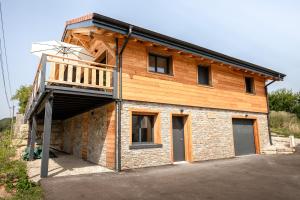 a house with a balcony on the side of it at Chalet authentique - Au cœur des Quatre Lacs in Le Frasnois