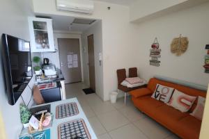 un soggiorno con un divano e una televisione di Great Escape - Wind Residences a Kaybagal