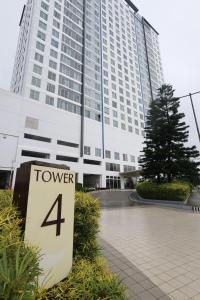 a tower sign in front of a building at Great Escape 5th FLR GARDEN VIEW in Kaybagal +6 photos