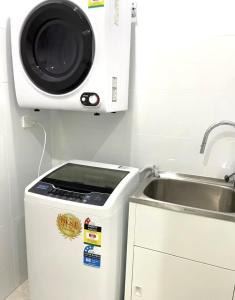 a microwave sitting on top of a refrigerator next to a sink at FlexiRoom on Abercrombie in Sydney